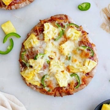 pineapple jalapeno pizza on a counter next to ingredients and a napkin