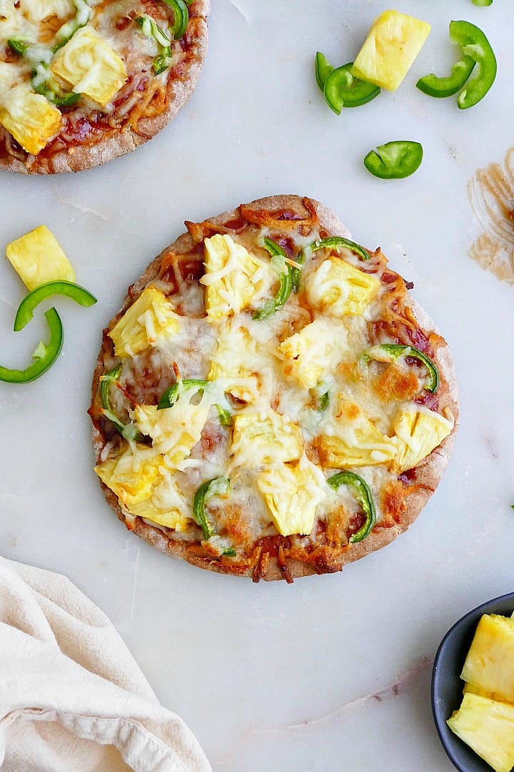 pineapple jalapeno pizza on a counter next to ingredients and a napkin