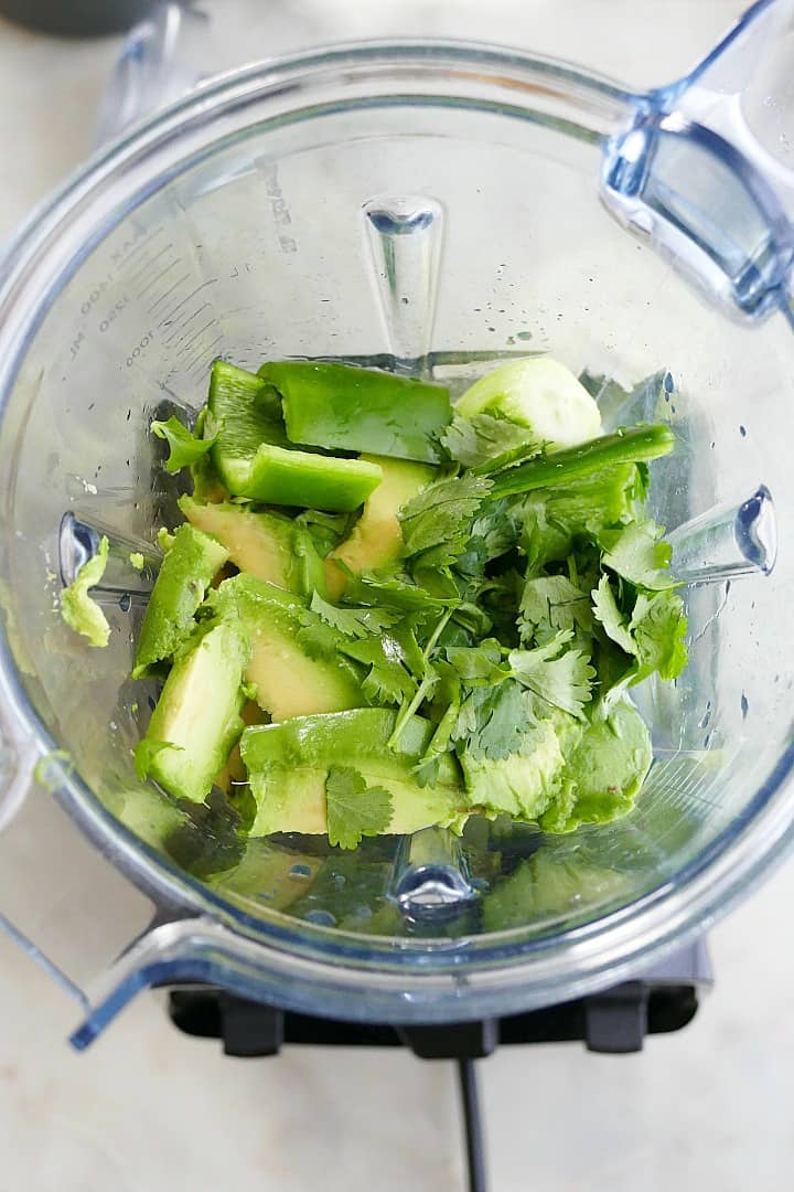 ingredients for cold cucumber avocado soup in a blender on a counter