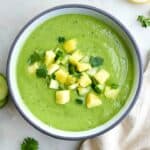 cucumber avocado soup topped with chopped pineapple in a bowl