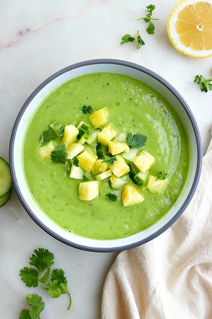 cucumber avocado soup topped with chopped pineapple in a bowl