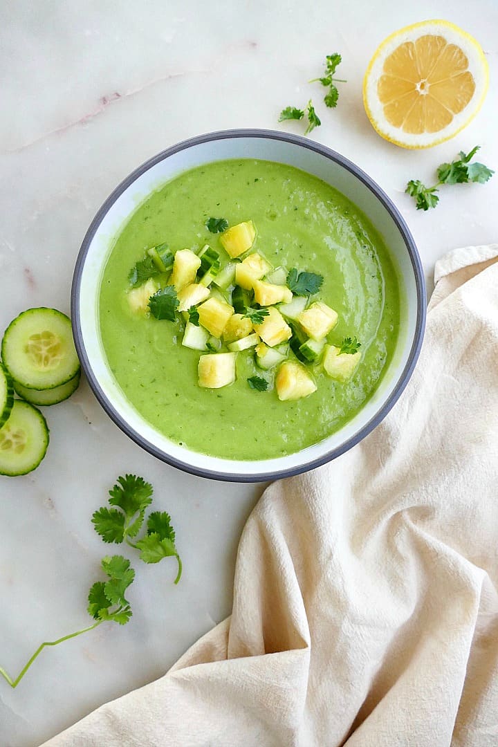 chilled cucumber avocado soup next to ingredients and a napkin