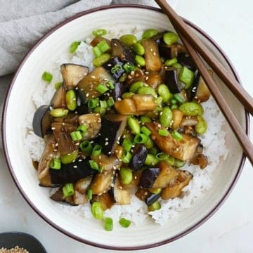 eggplant teriyaki stir fry in a serving dish with brown chopsticks on the edge