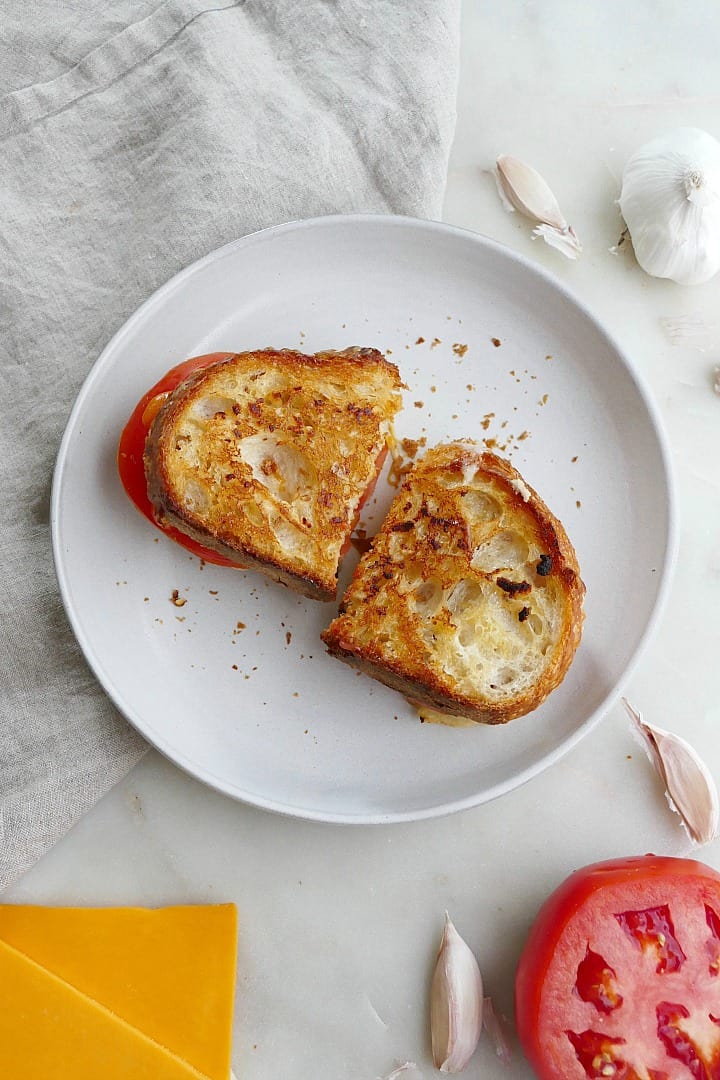 garlic bread grilled cheese sliced in half on a white serving plate