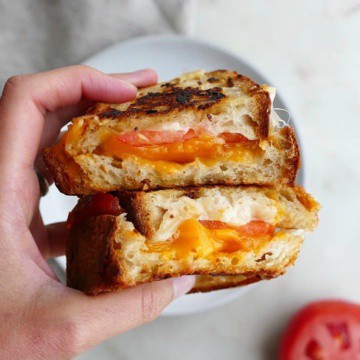 two halves of garlic bread grilled cheese on top of each other in a hand