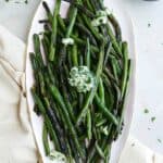 herb and garlic butter green beans displayed on an oval serving platter
