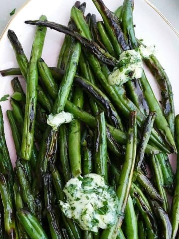 square image of of garlic butter green beans on a serving platter