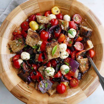 grilled panzanella salad in a wooden bowl with a serving spoon