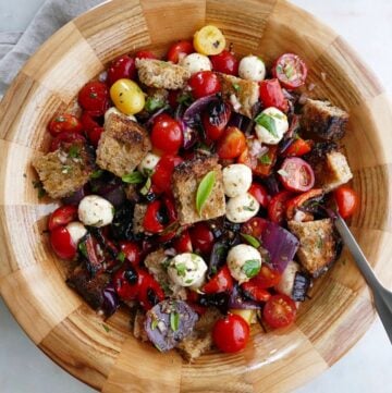 grilled panzanella salad in a wooden bowl with a serving spoon