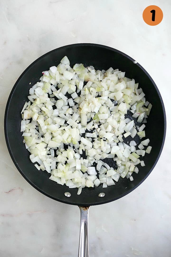 diced onions cooking in a skillet with the number one in the top right corner