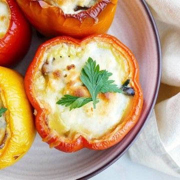 close-up image of a breakfast stuffed pepper topped with cheese and parsley on a serving platter