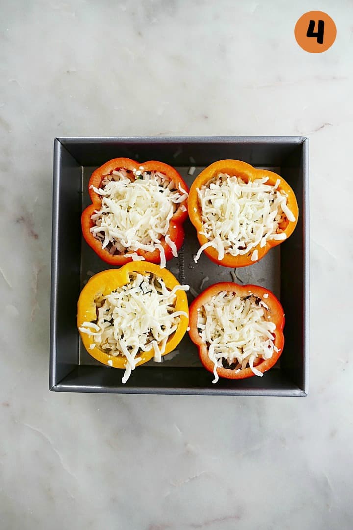 stuffed bell peppers with cheese in a baking dish with the number three in the corner