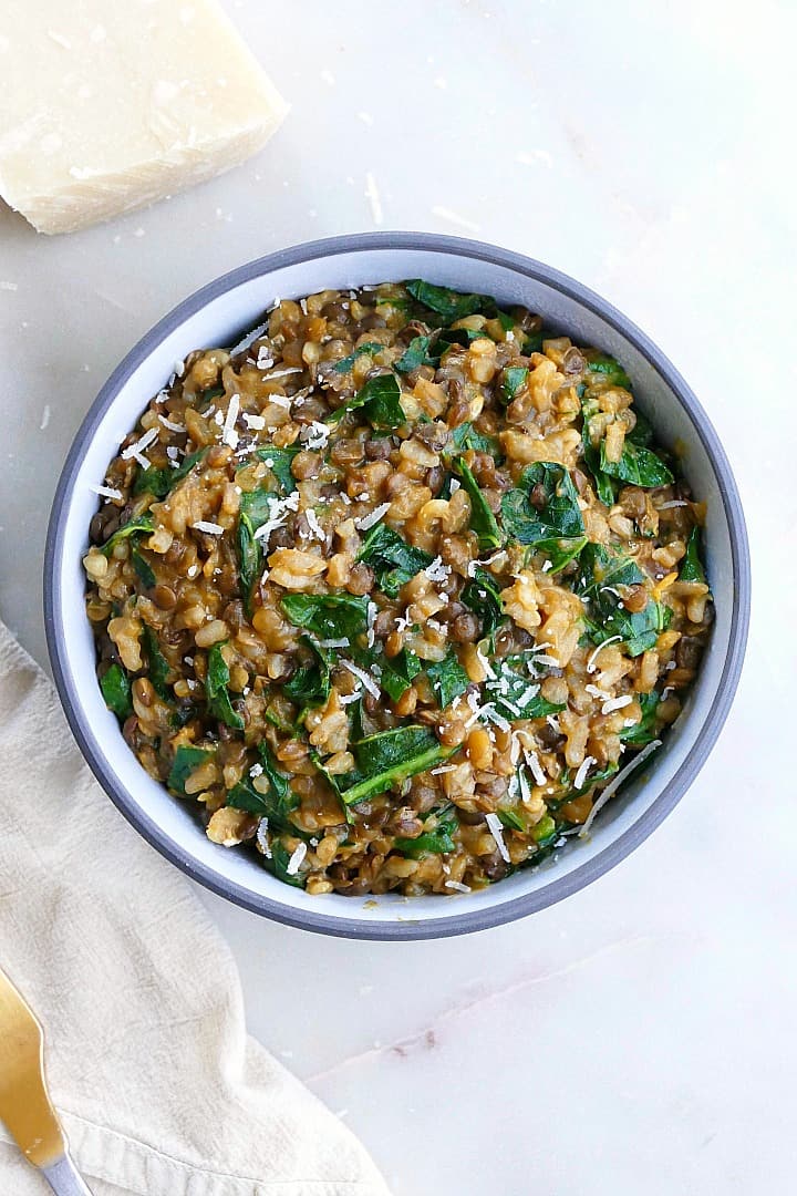 lentil risotto with collards and parmesan in a serving bowl on a counter