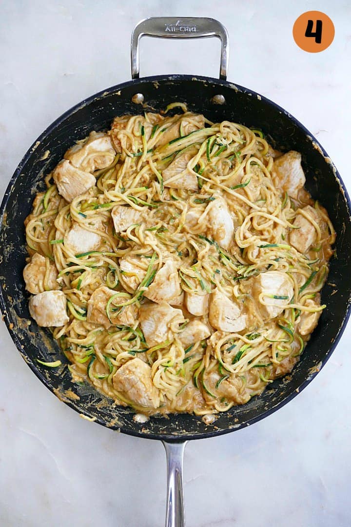 peanut zucchini noodles with chicken in a large black skillet