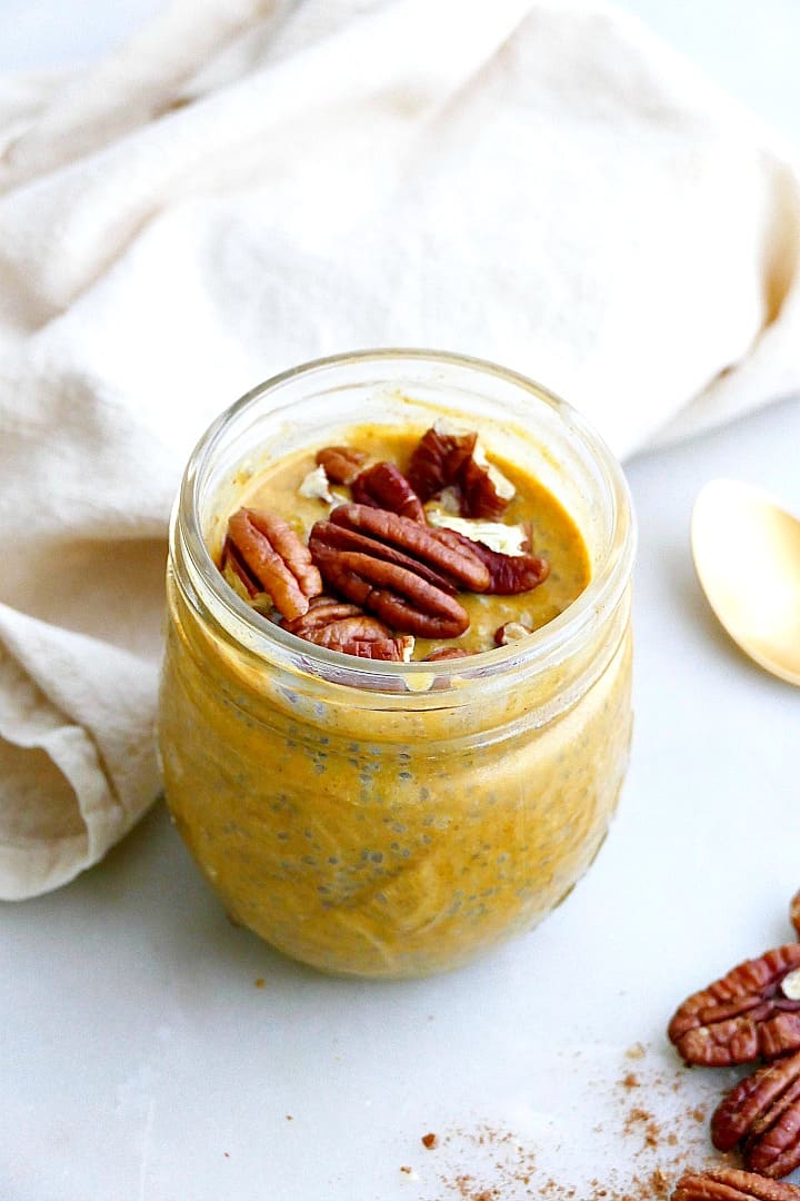 pumpkin chia pudding in a jar with pecans on top, next to a napkin