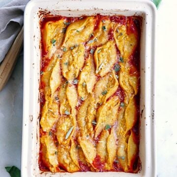 finished ricotta and pumpkin stuffed shells in a large baking dish on a counter