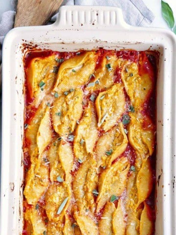 square image of pumpkin stuffed shells in a baking dish on a counter