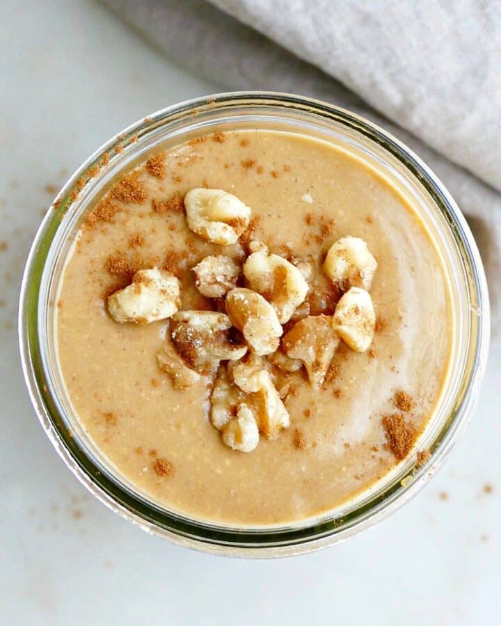 square image of sweet potato smoothie with walnuts and cinnamon on a counter