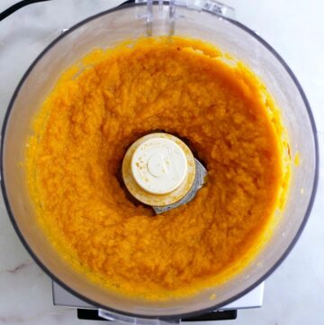 pureed butternut squash in a food processor on top of a counter