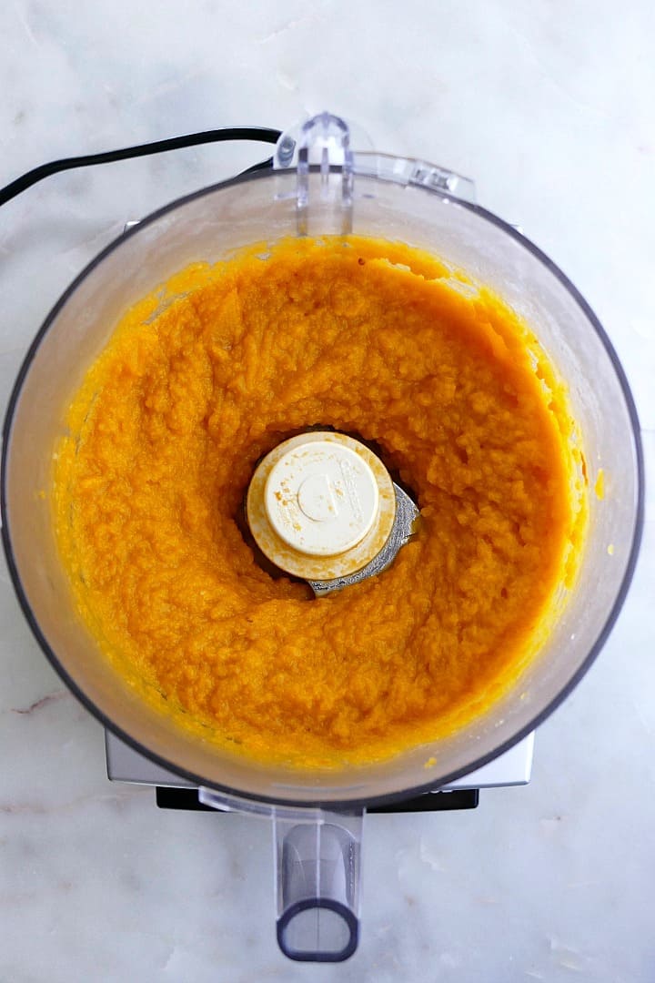 pureed butternut squash in a food processor on top of a counter