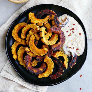 delicata squash fries with spicy white bean dip on a platter on top of a napkin