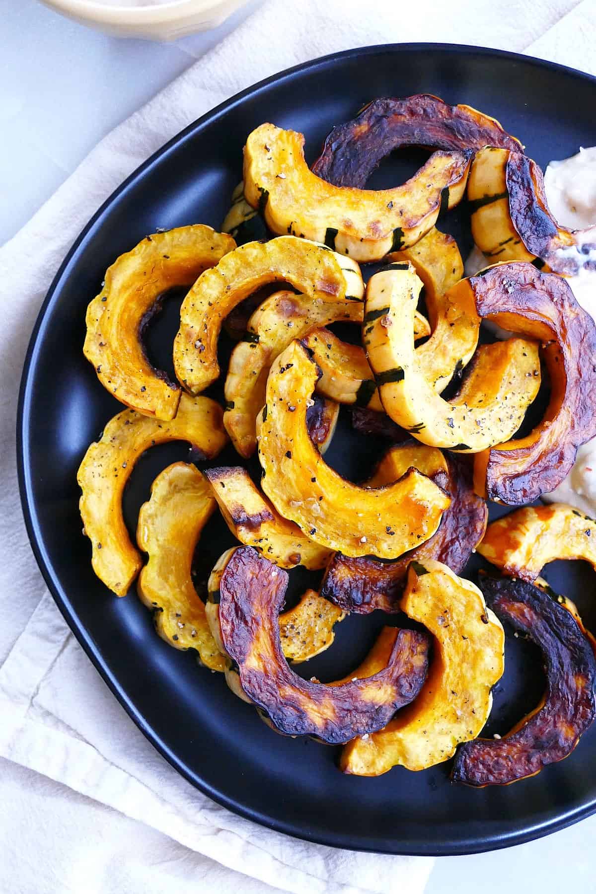 close-up image of delicata squash fries on a serving plate on a napkin