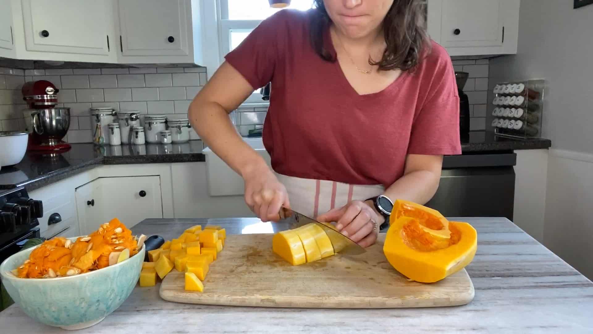 woman cutting a piece of squash into 1-inch strips on a cutting board