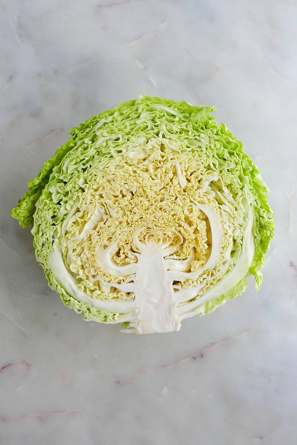 half of a head of savoy cabbage cut side up on a counter