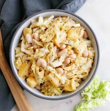 bowl with stewed cabbage and apples on top of a napkin on a counter