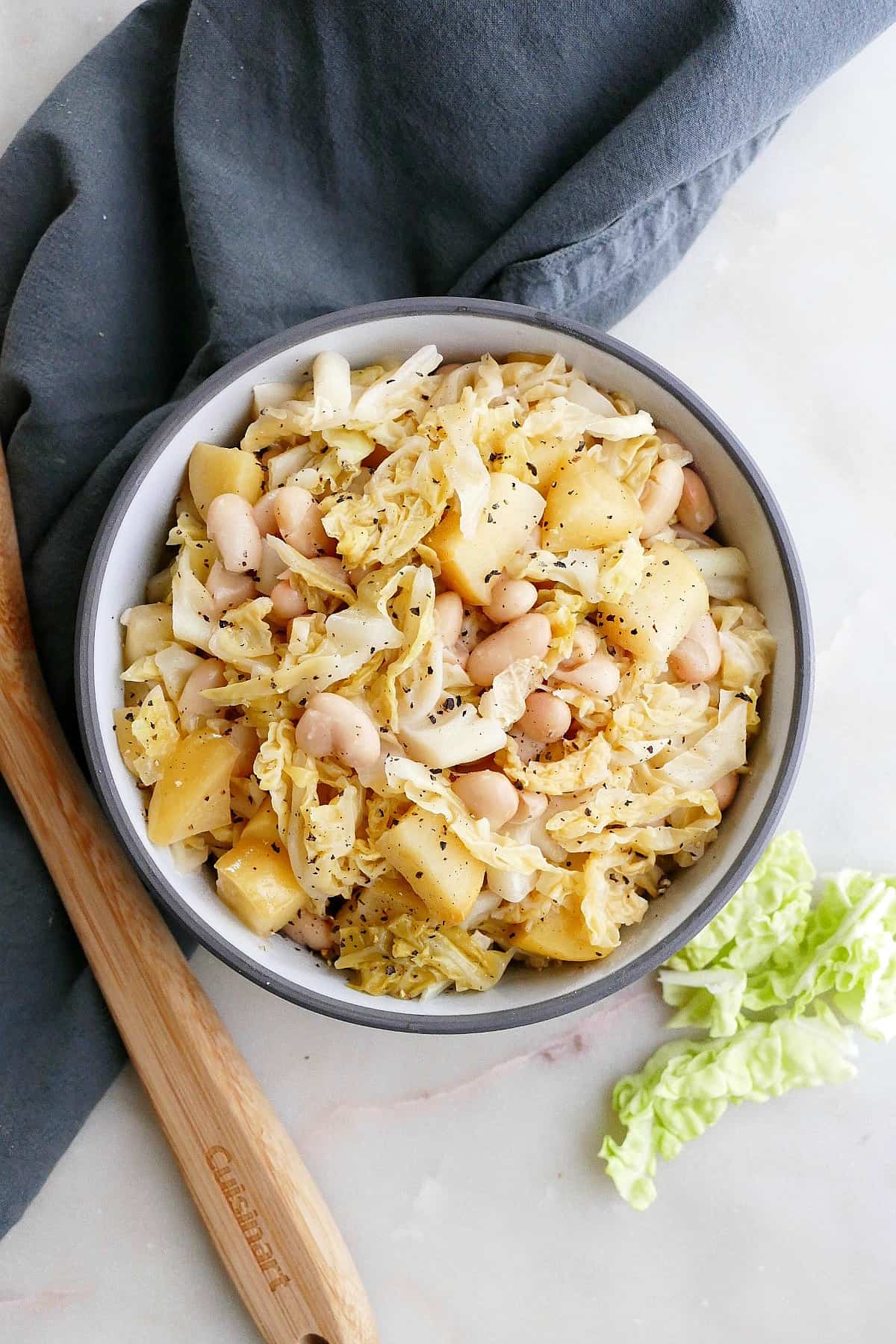 bowl with stewed cabbage and apples on top of a napkin on a counter