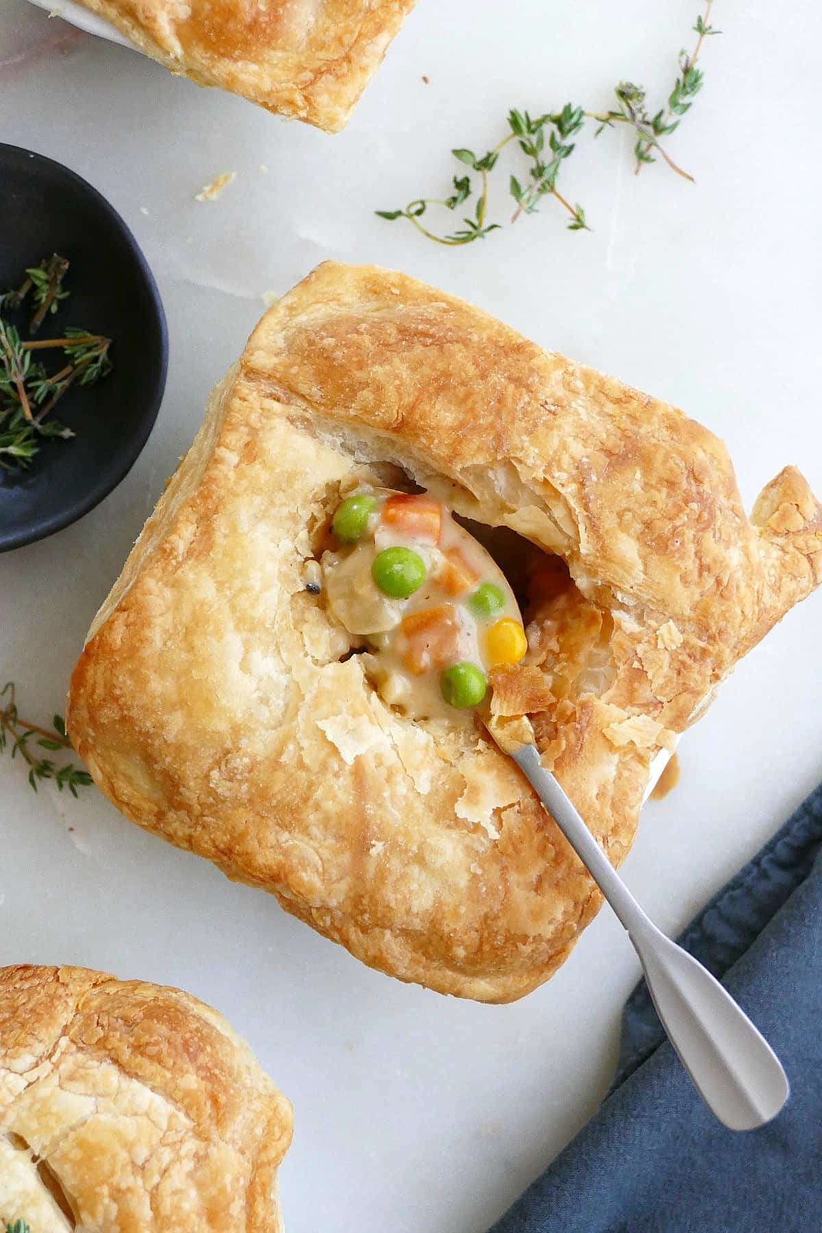 mini vegetarian pot pie with a small spoon with filling in the center