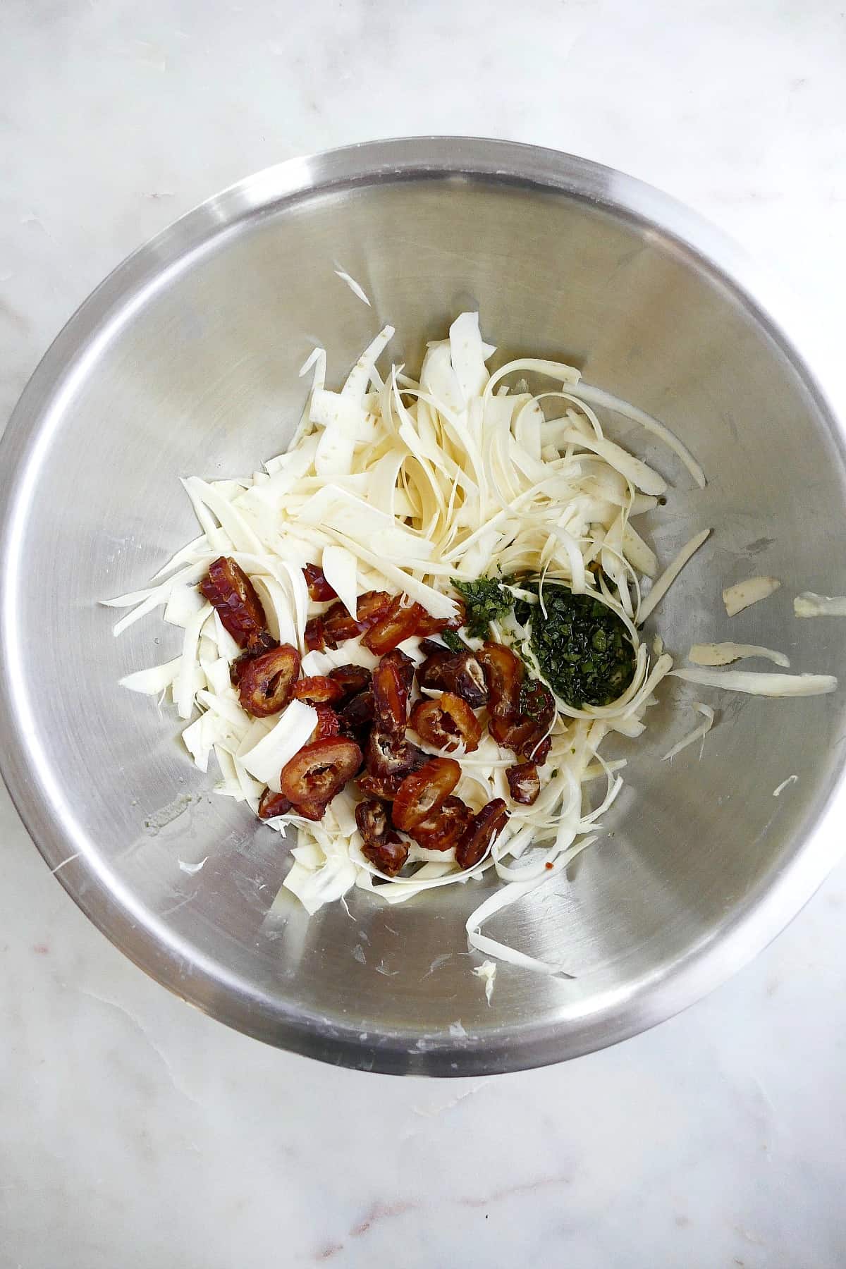 shaved parsnips, sliced dates, and sage dressing in a mixing bowl before combined