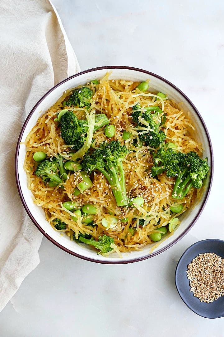 spaghetti squash stir fry with edamame and broccoli in a serving bowl on a counter