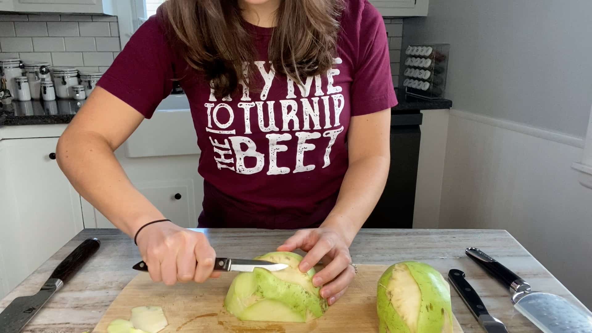 photo of a woman peeling a kohlrabi with a paring knife