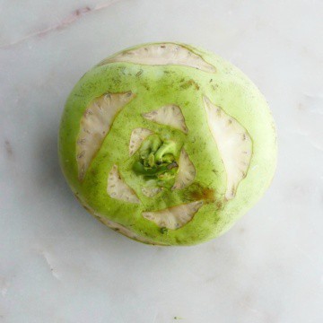 a large green kohlrabi sitting on a white counter