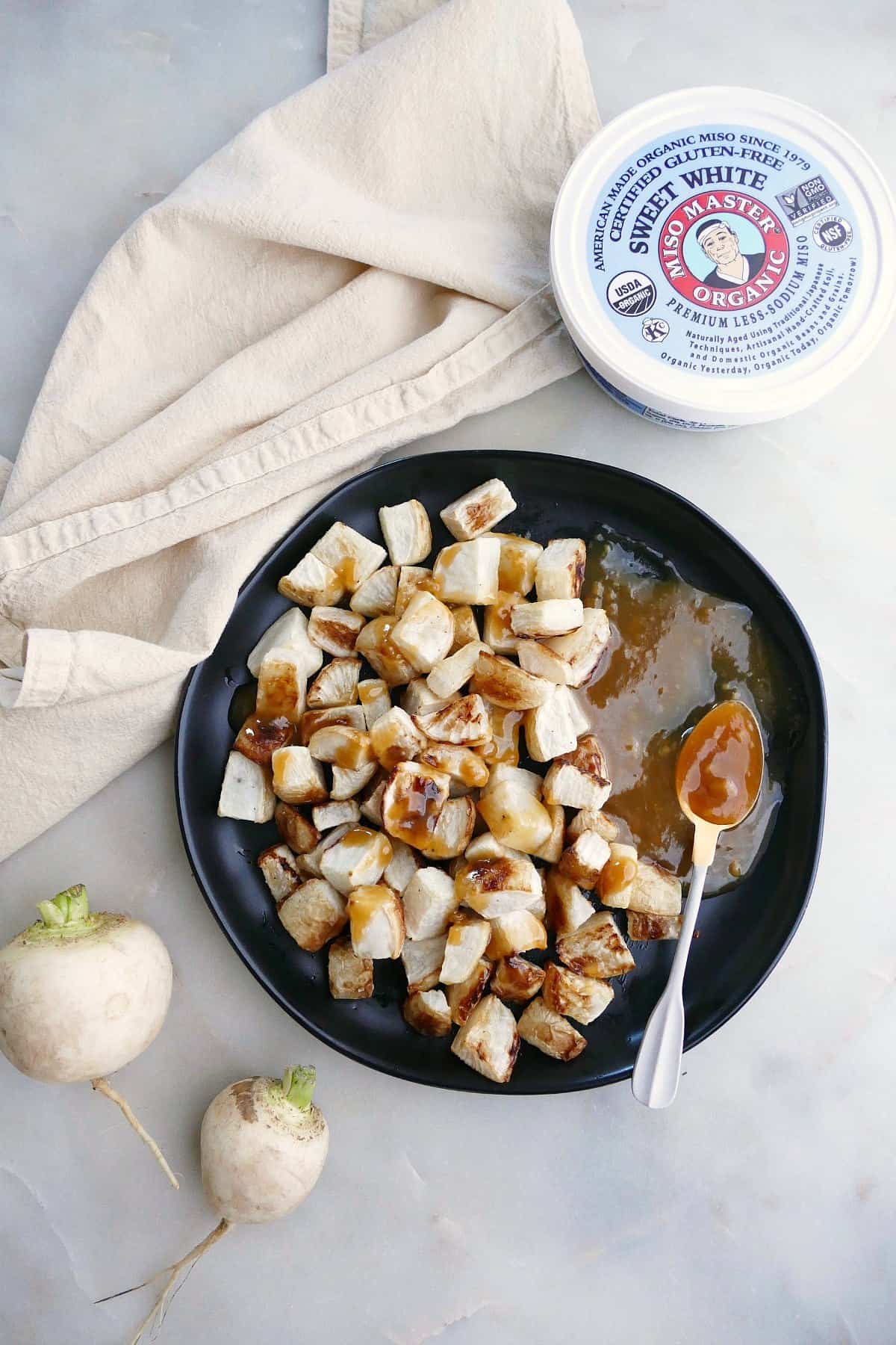 serving plate with roasted turnips and maple miso butter next to ingredients on a counter