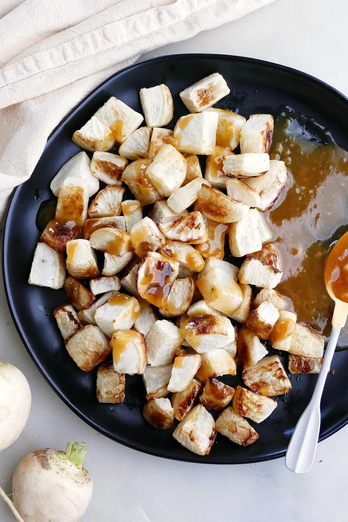 close image of roasted Japanese turnips with miso sauce on a serving plate