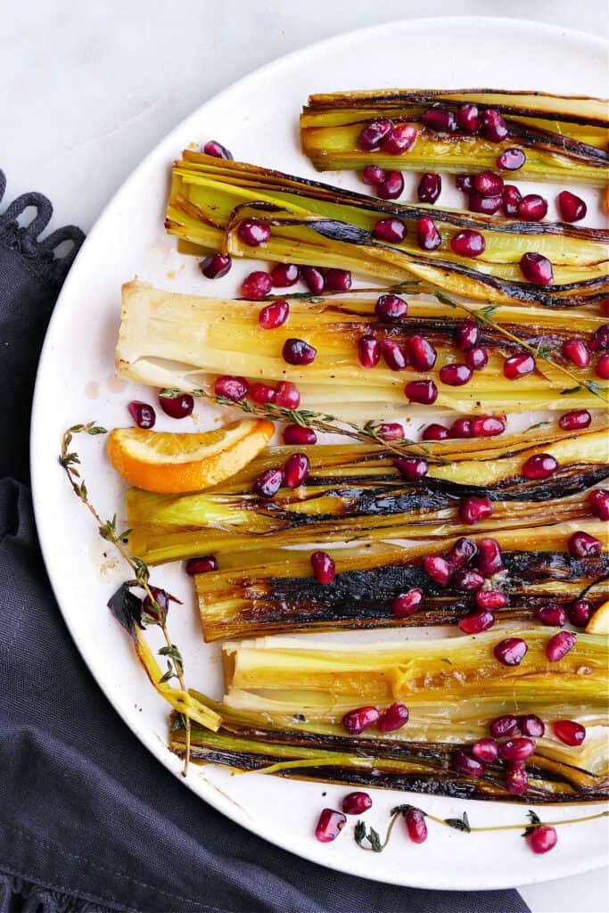 caramelized leeks with orange ginger pomegranate relish on a platter on a counter
