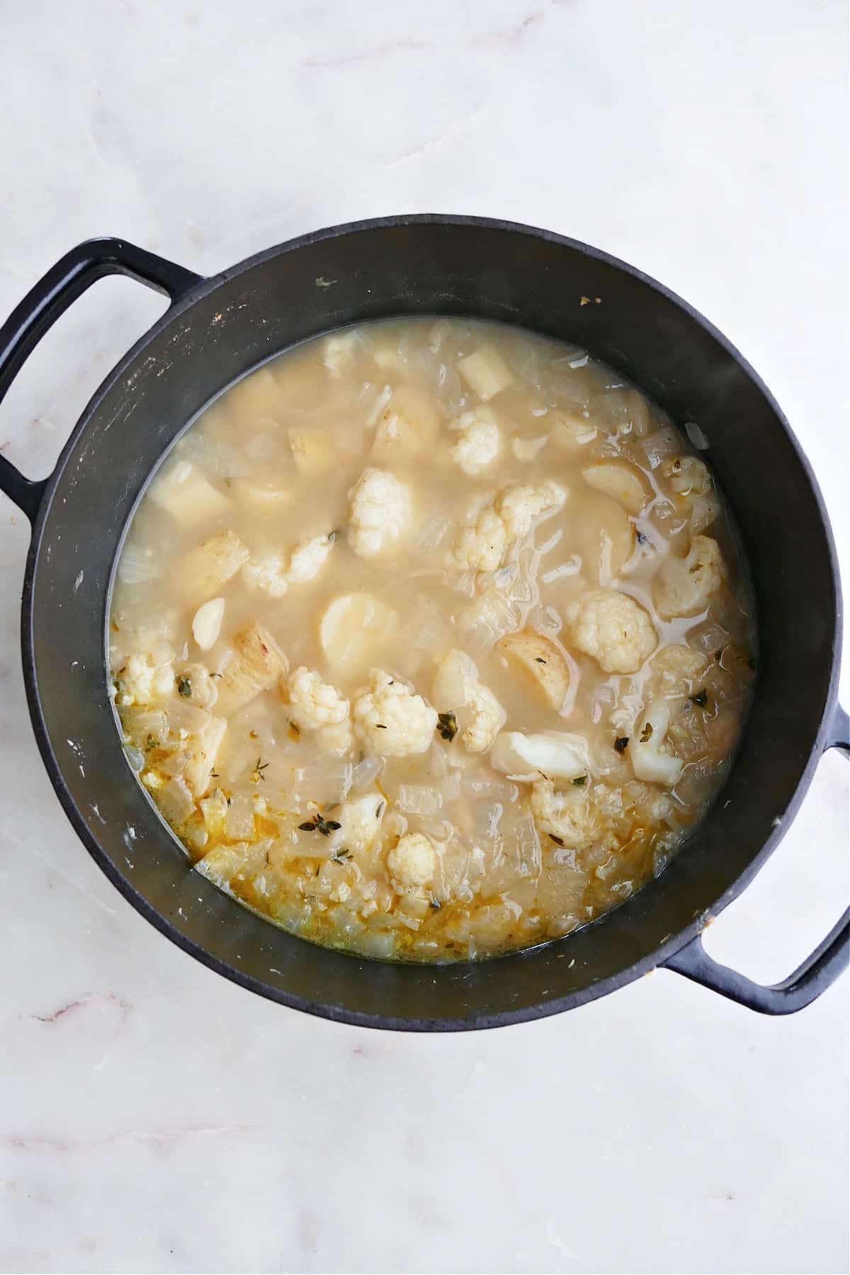 cooked cauliflower, parsnips, onions, and white beans in veggie broth in a large pot