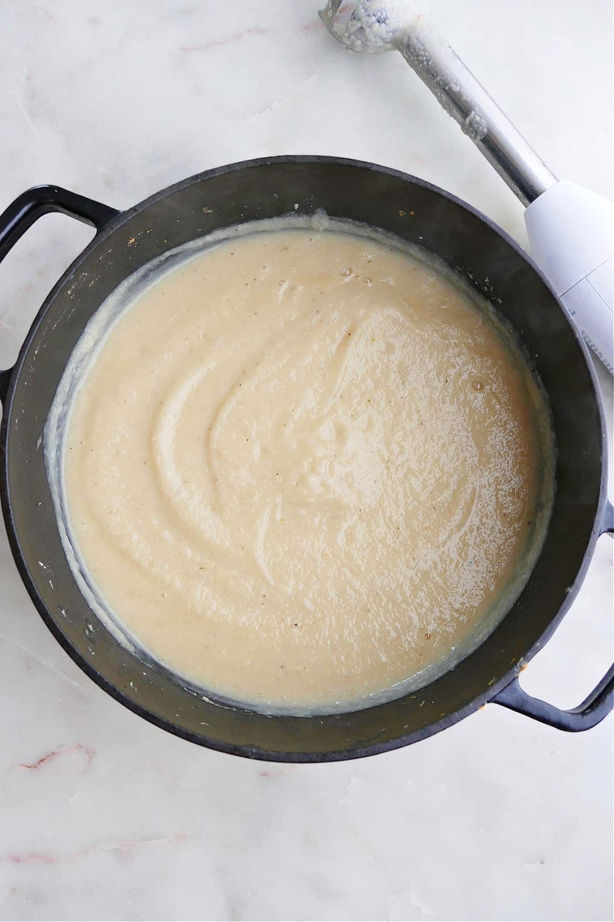 pureed cauliflower and parsnip soup in a large pot on a counter