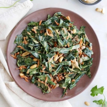 collard greens salad with peanut dressing on a brown serving dish on a counter