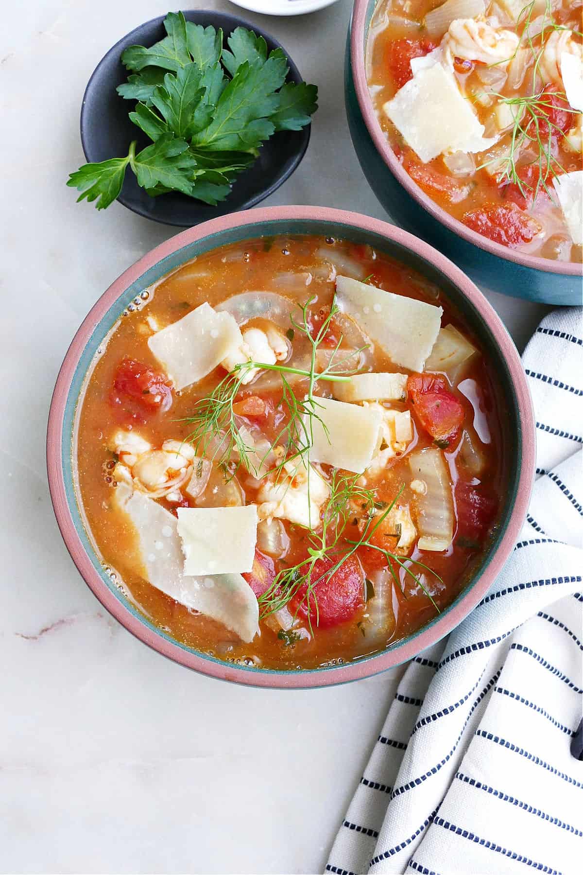 bowl of fennel stew with shrimp in a soup bowl with toppings