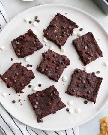 square image of 7 sweet potato brownies on a serving plate with chocolate chips