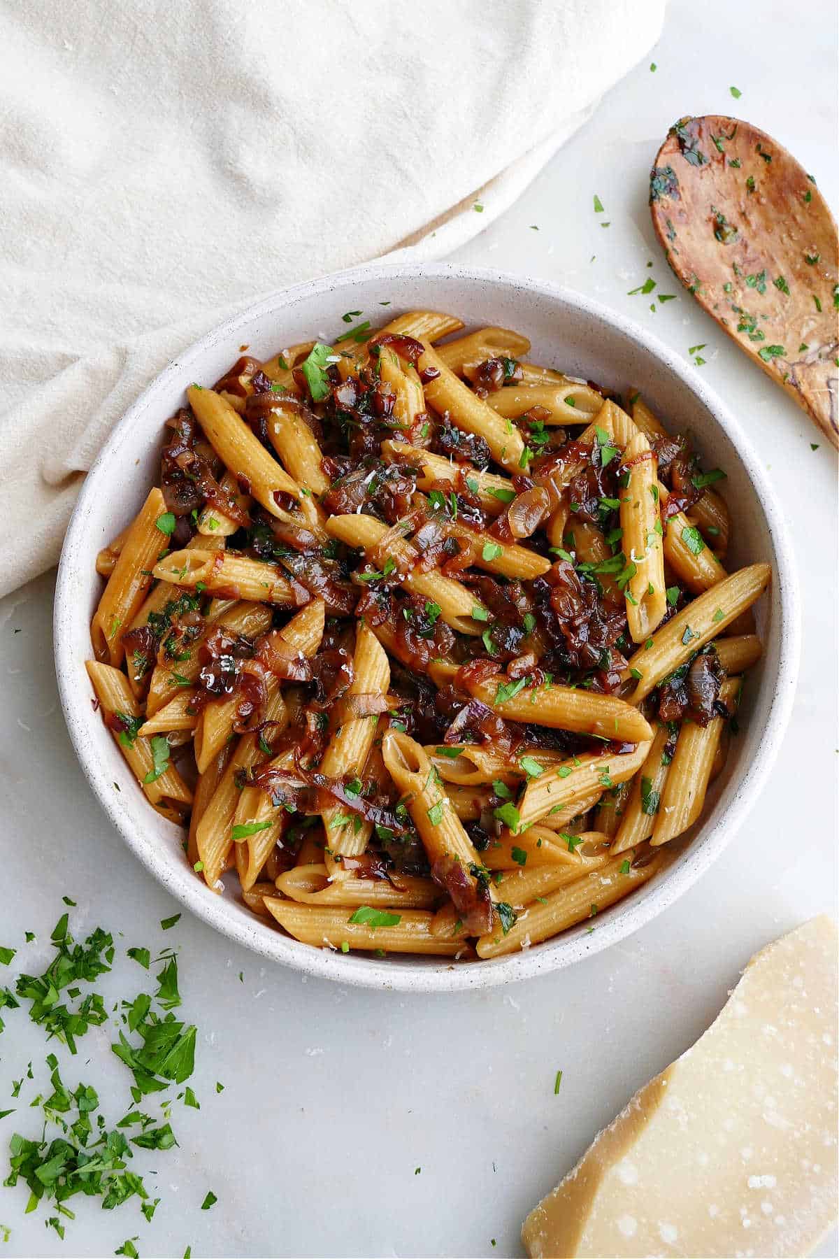 caramelized shallot pasta in a serving bowl next to ingredients on a counter