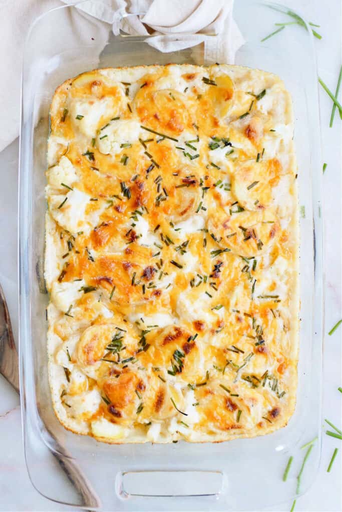 oven baked cauliflower and potato bake in a glass casserole dish on a counter