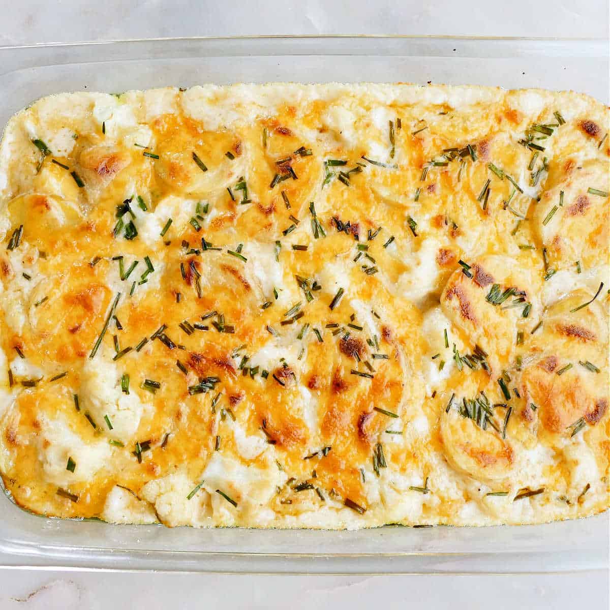 cauliflower and potato bake with cheese and chives in a dish after baking