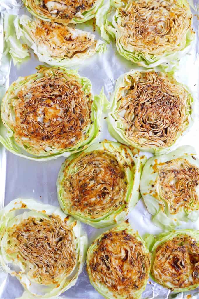 cabbage steaks rubbed with blackened seasoning on a baking sheet lined with foil