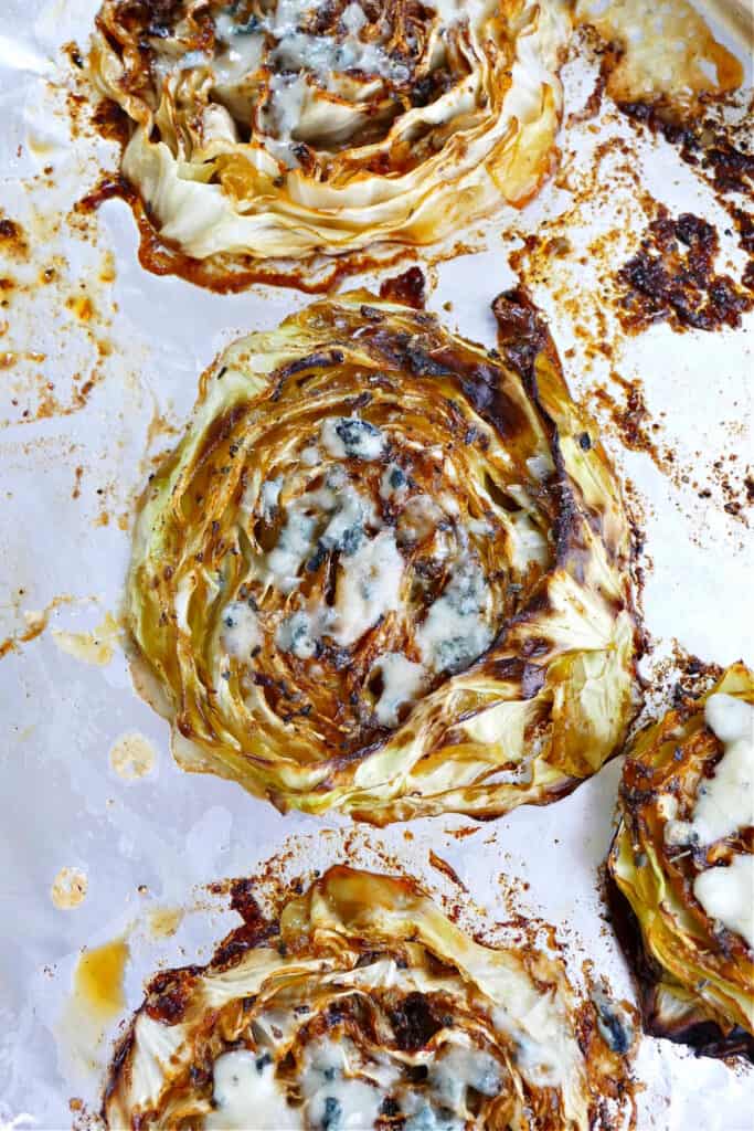 black and blue roasted cabbage steaks after cooking on a baking sheet