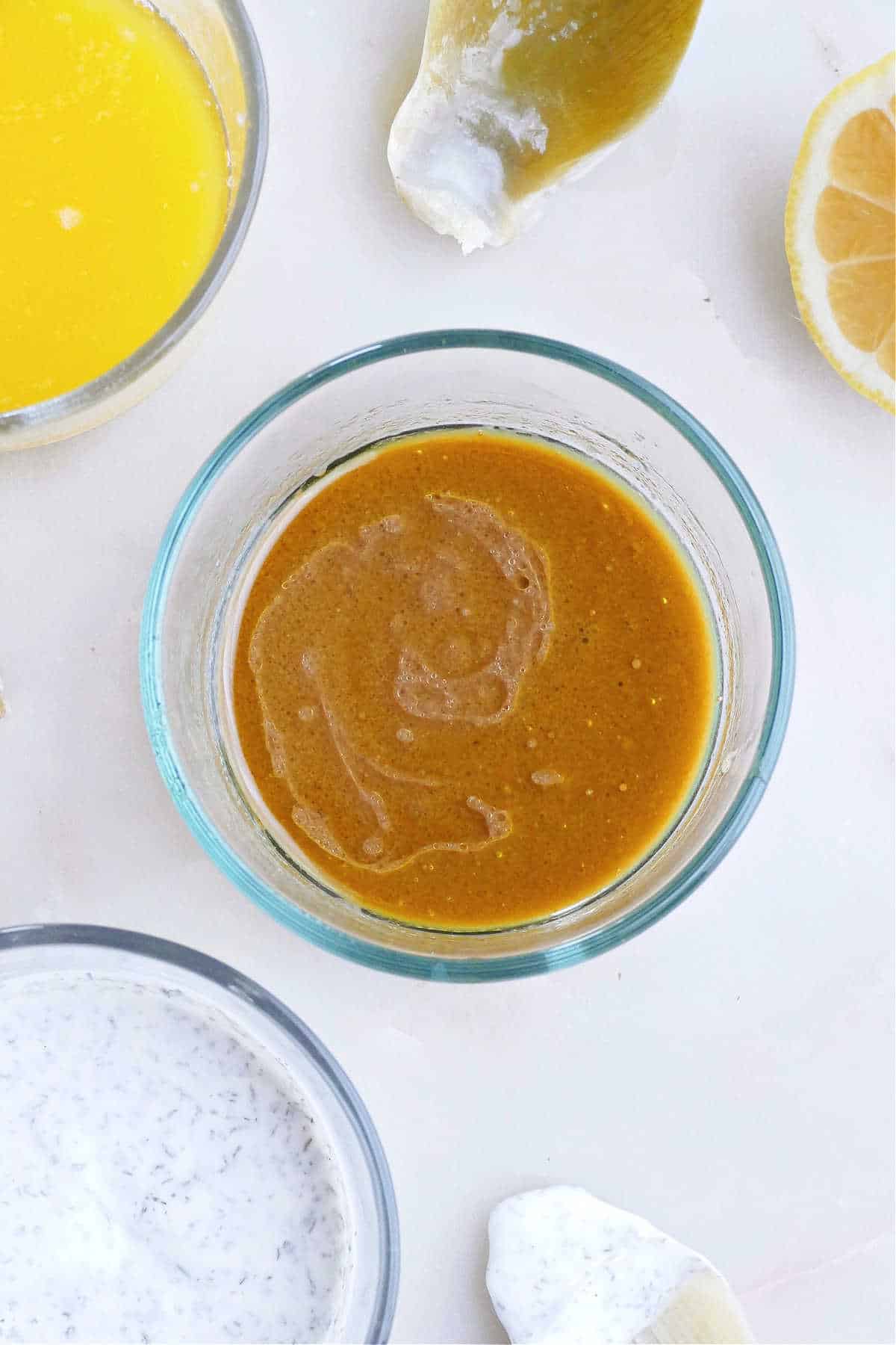 balsamic vinaigrette artichoke dipping sauce in a glass container on a counter