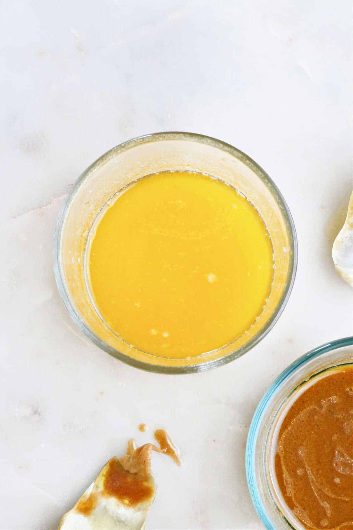 lemon butter garlic dipping sauce in a glass container on a counter